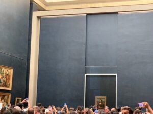 crowded room showcasing the Mona Lisa at the Louvre